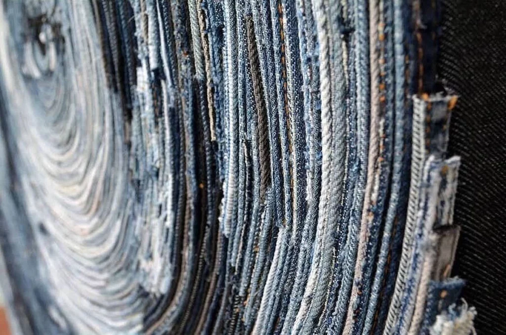 Close da obra de arte sustentável de Deniz Sağdıç com padrões de tecido jeans em espiral.