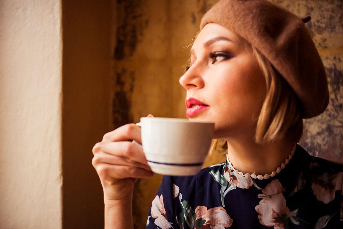 Woman in beret enjoying a cup of tea