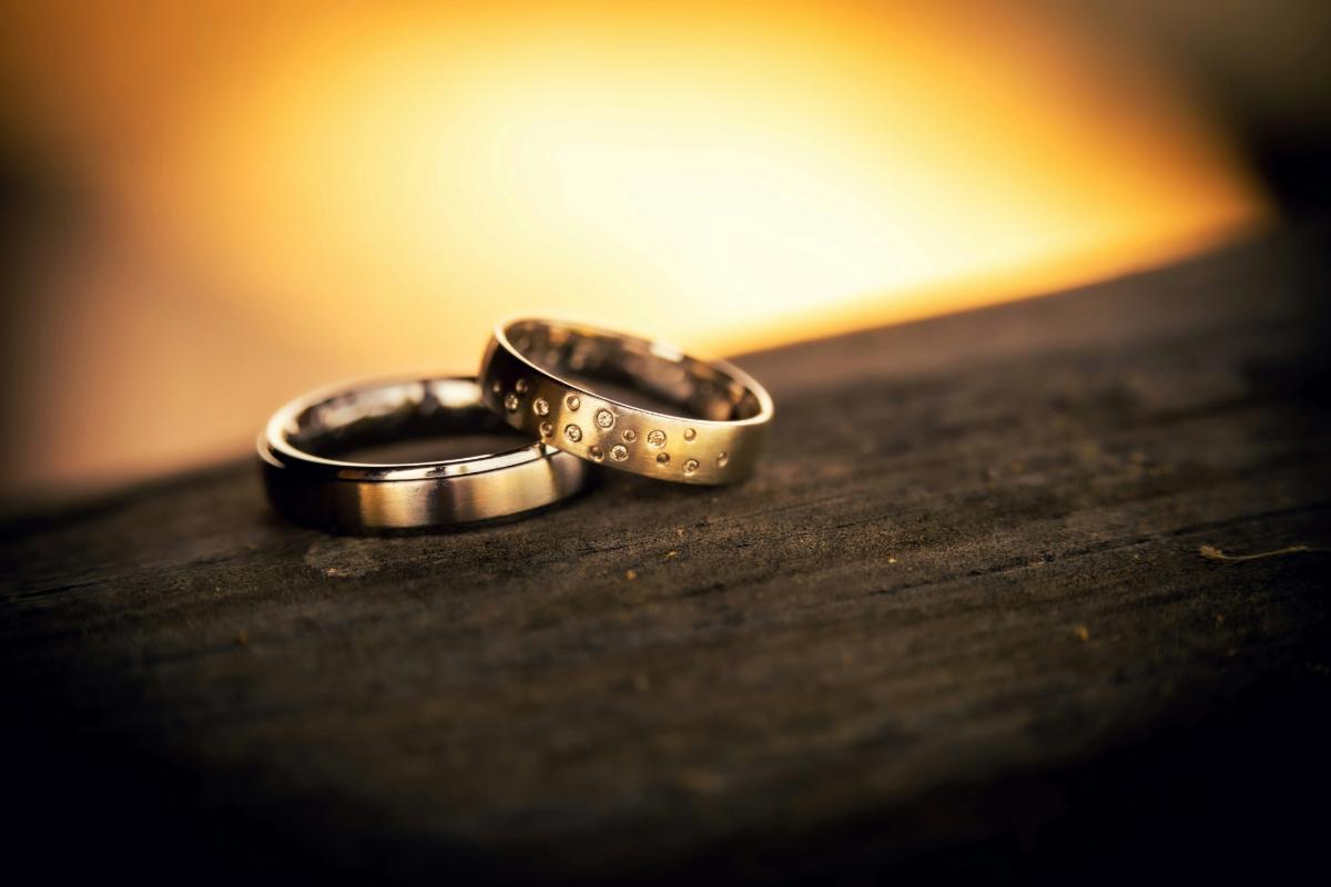 Two wedding rings on wooden surface