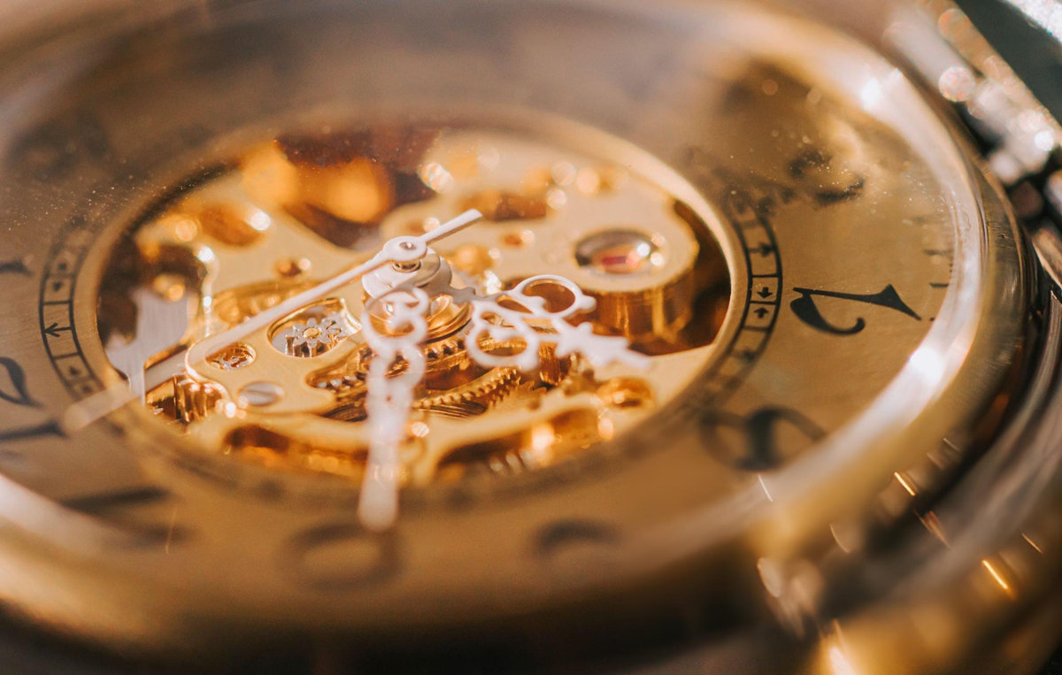 Close-up of luxury watch mechanical movement showing intricate gold gears and complications demonstrating craftsmanship and technical achievement that makes timepieces appreciate in value
