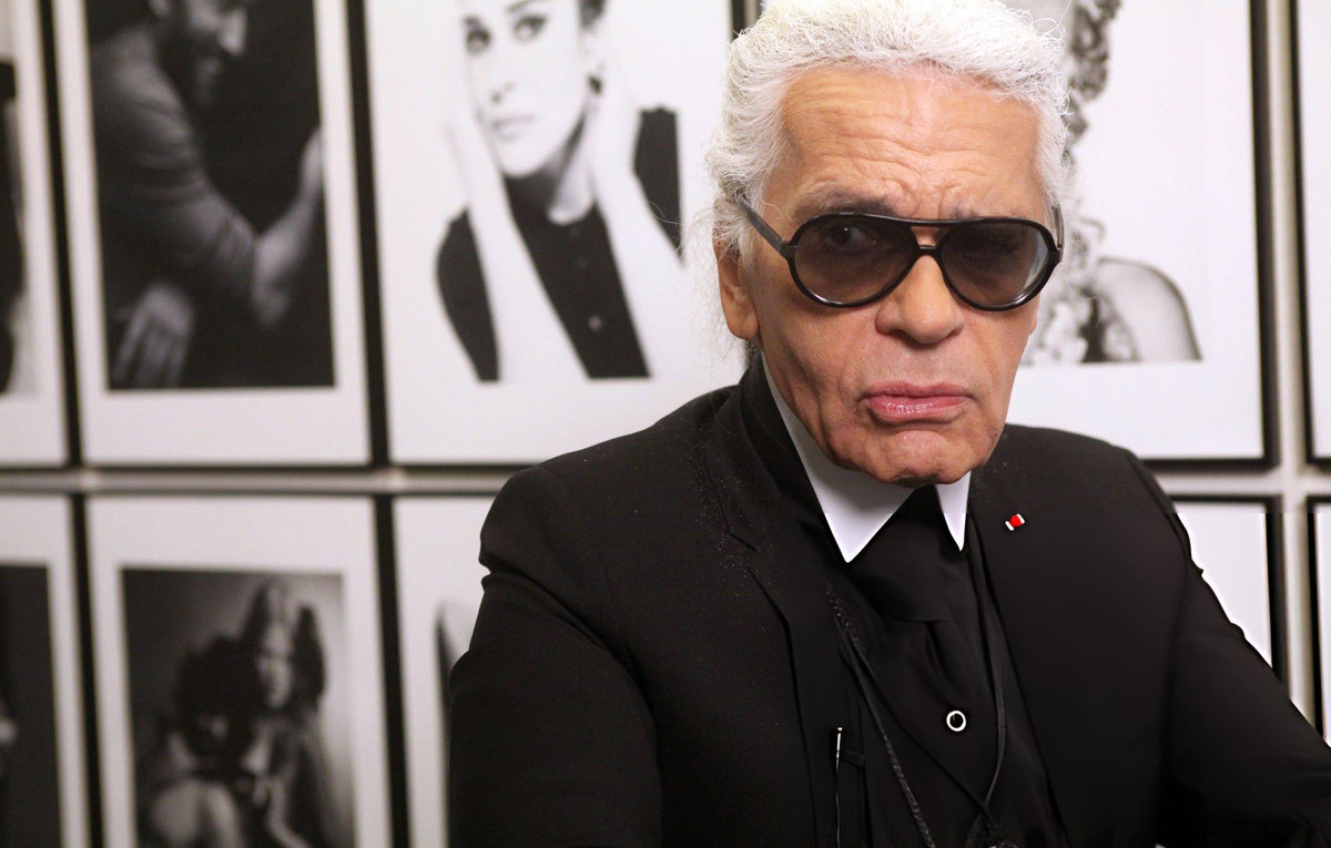 Karl Lagerfeld photographed in front of his black and white portraits, Paris, 2010