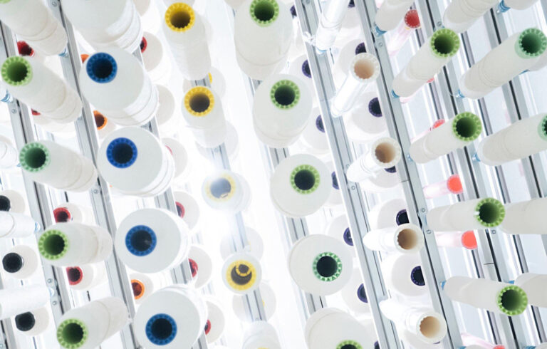 Industrial thread spools on a manufacturing rack