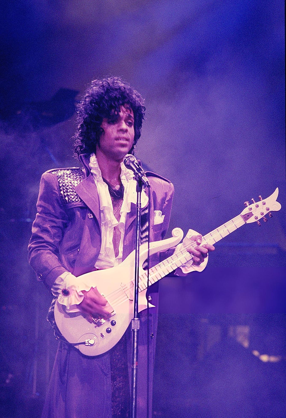 Prince performing live on stage in a purple outfit during the 1984 Purple Rain tour at Rosemont Horizon in Chicago