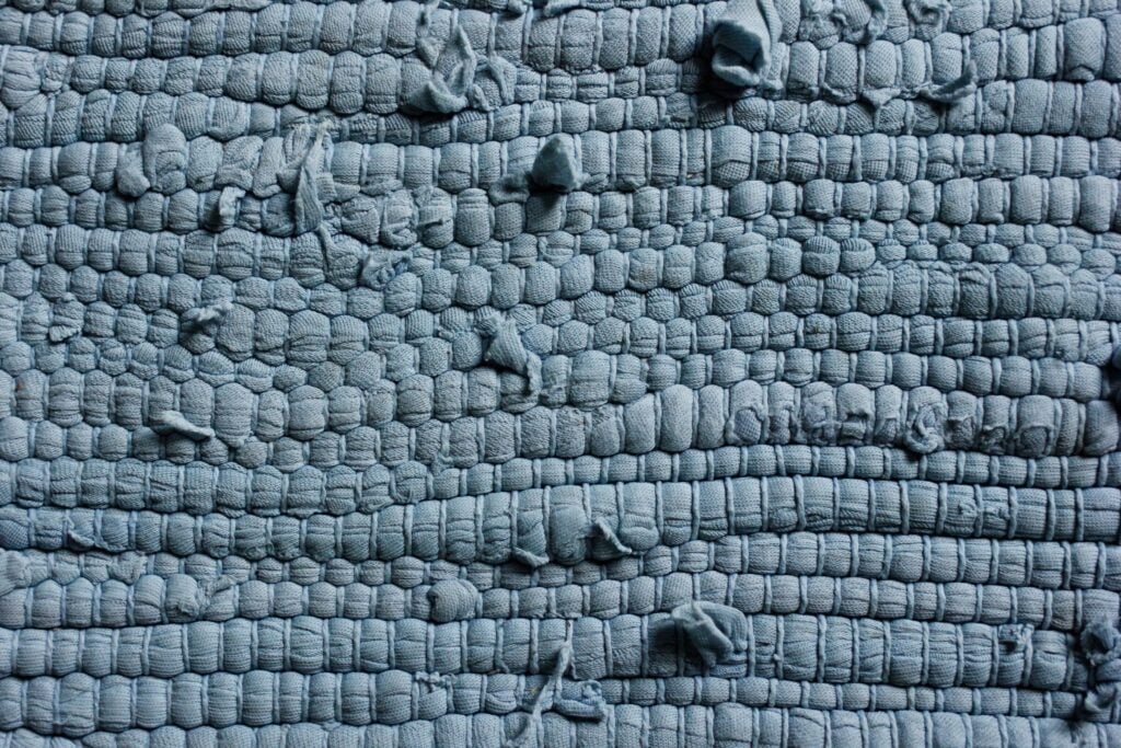 Close-up of textured blue woven fabric with raised threads.